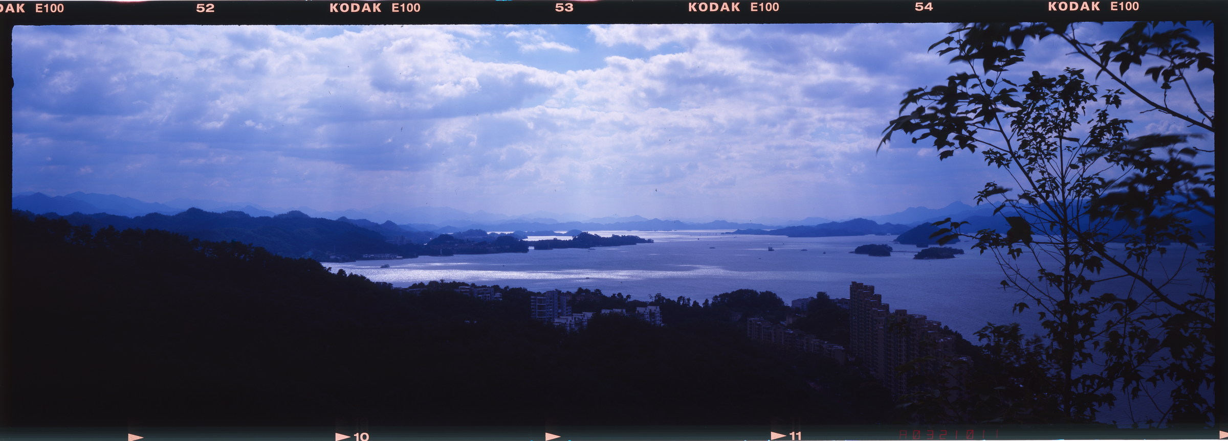 蓝色云层下的湖区与层叠岛屿，完整保留连续编号与胶片片边。