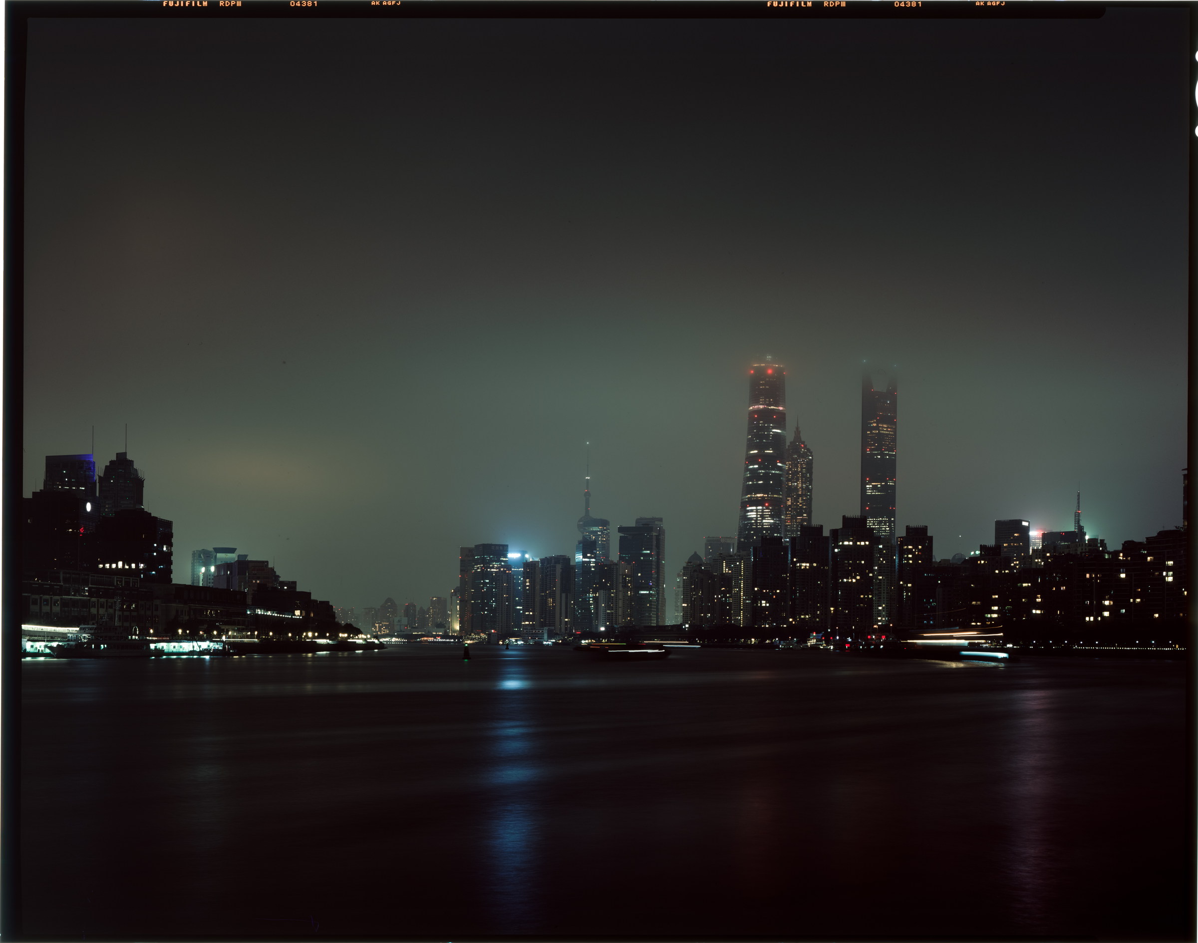 上海陆家嘴夜色与江面船影，灯光在水上缓缓拉开。